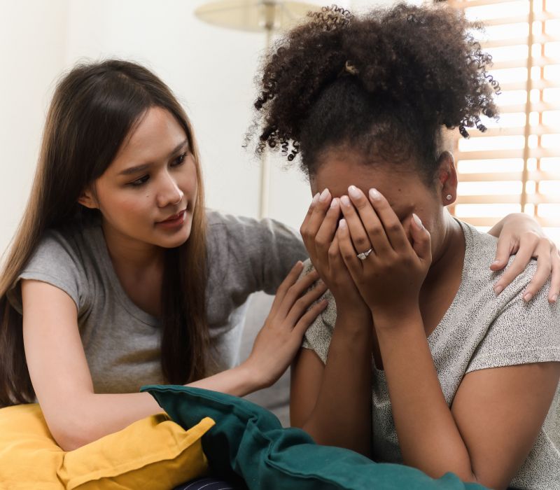 a woman comforting her female friend